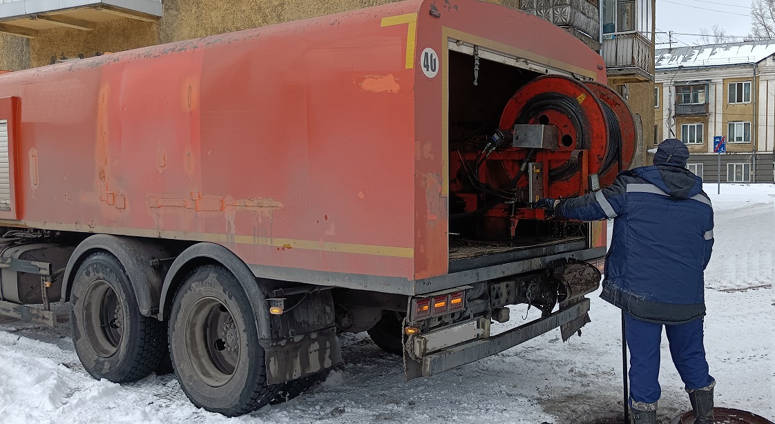 Каналопромывочная машина и работник прочищают засор в канализационной системе в Жукове